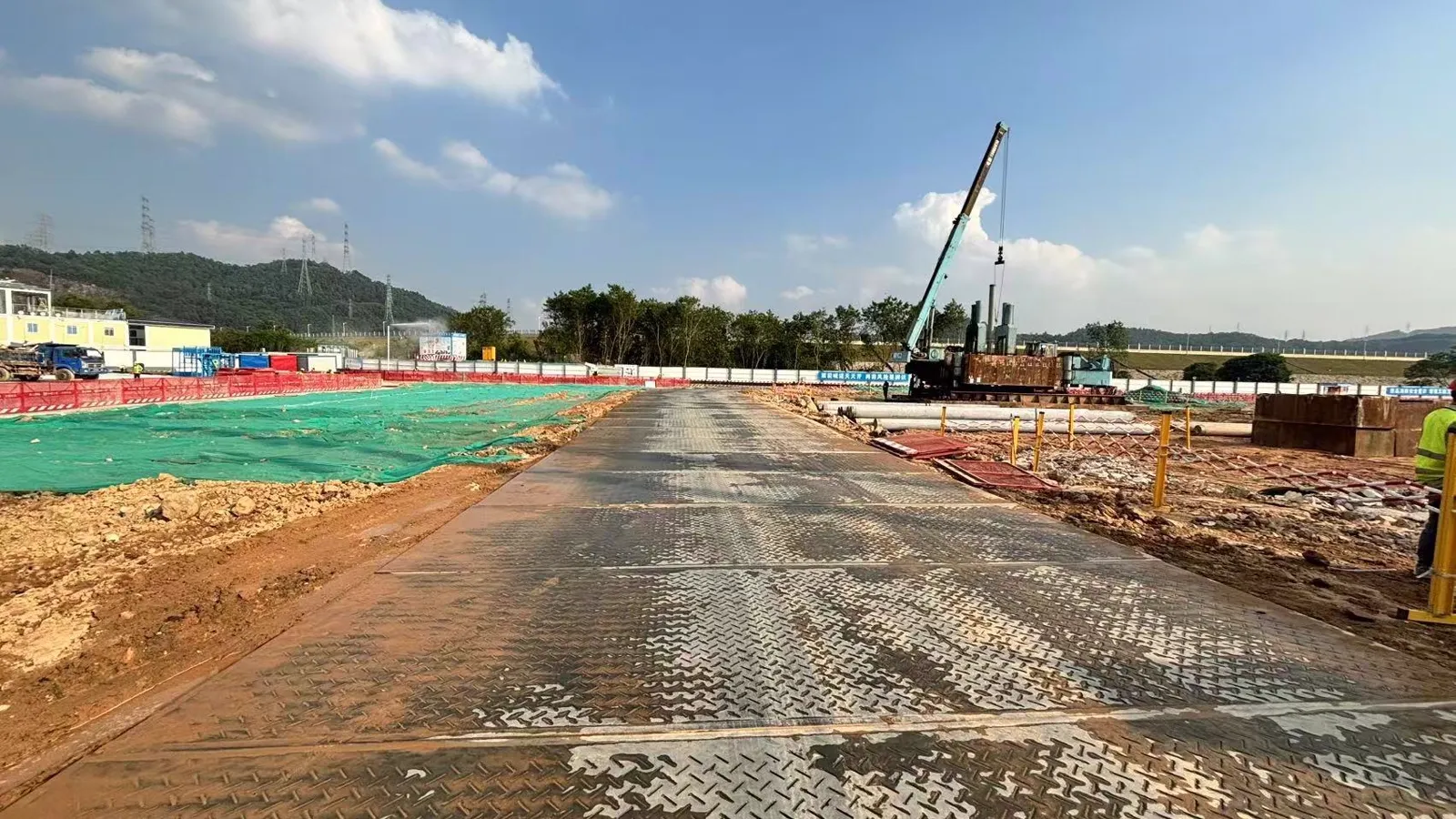 Mobile crane working on an HDPE mat platform at a construction site