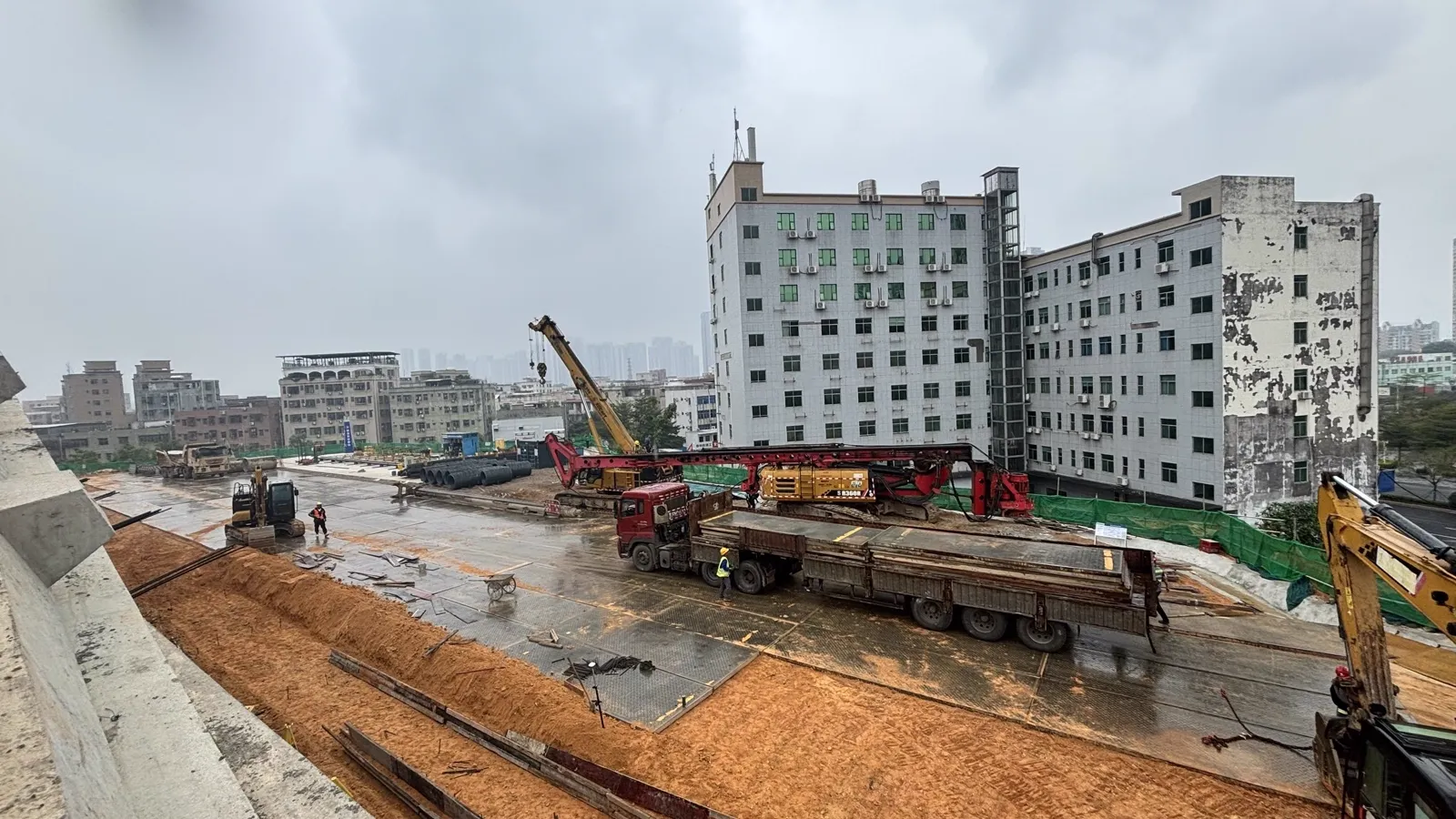 Excavator and site plant working from a mat platform over mud