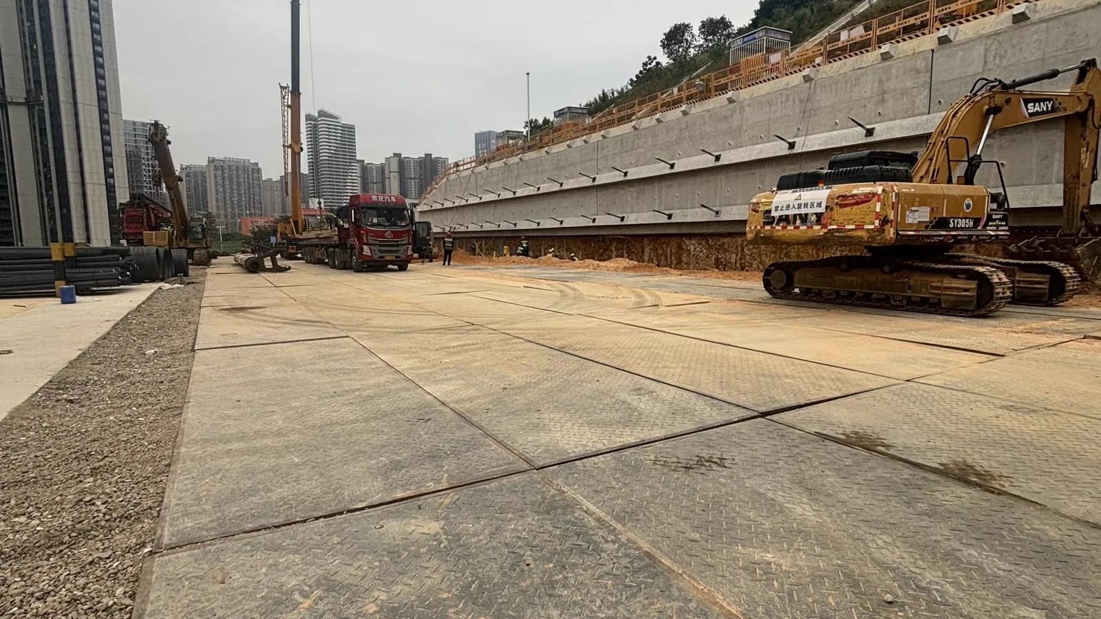 HDPE temporary road mats forming an access route across a large graded site